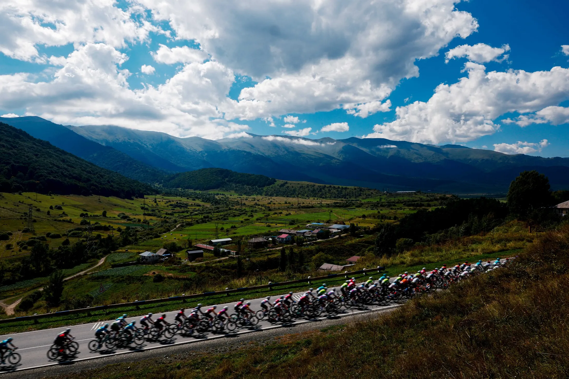 The peloton on the road above the valley